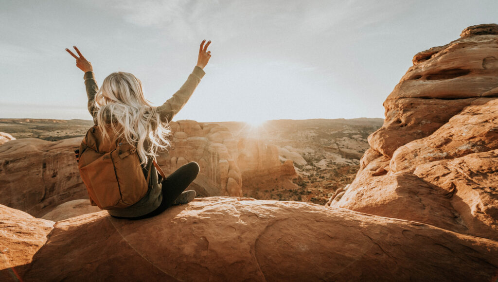 Girl Peace Signs Hiking In Moab Utah